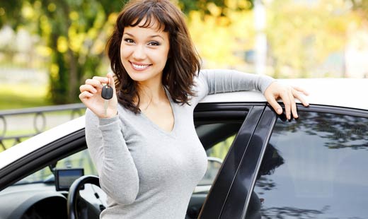 smiling woman holding car keys up
